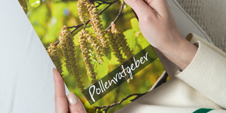Eine Person hält den Pollenratgeber von aha! Allergiezentrum Schweiz in den Händen