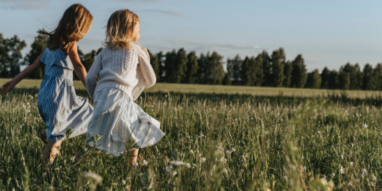 Deux enfants jouent dans une prairie