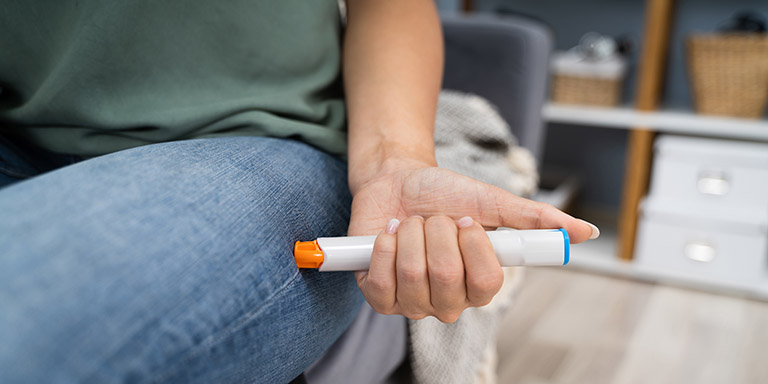 Une personne s'injecte une seringue préremplie d'adrénaline