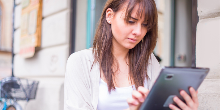 Une femme regarde une tablette et s'informe