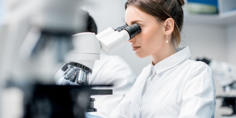 Une femme travaille avec un microscope